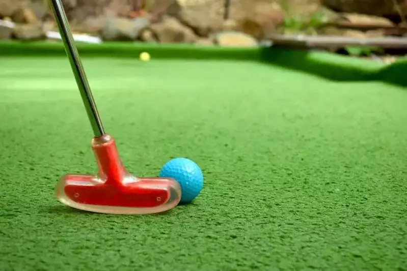 red golf club and ball on putt putt course