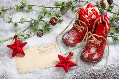 red boots in the snow sitting next to a letter for santa