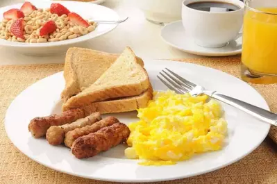 Eggs, sausage, toast, cereal, coffee, and orange juice.