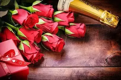 Red roses, champagne bottle and chocolate box for romance package