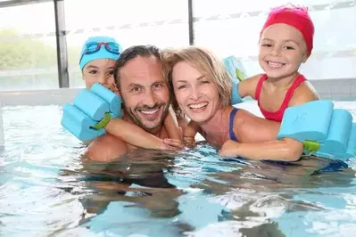 Family playing in an indoor pool