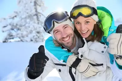 A couple on a ski trip together in the snow.