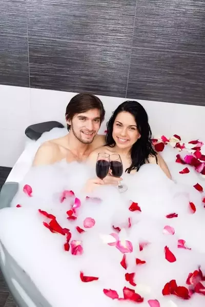 Romantic couple sipping wine in their Pigeon Forge hotel room with a Jacuzzi