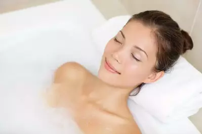 Woman enjoying a bubble bath in her Pigeon Froge hotel room with a Jacuzzi