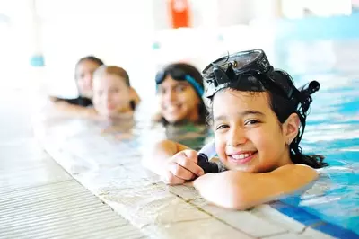 4 kids playing in an indoor pool