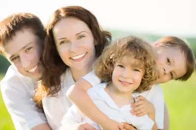 Happy family of four standing outside