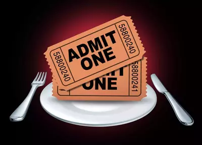 Two "Admit One" dinner show tickets on a dinner plate