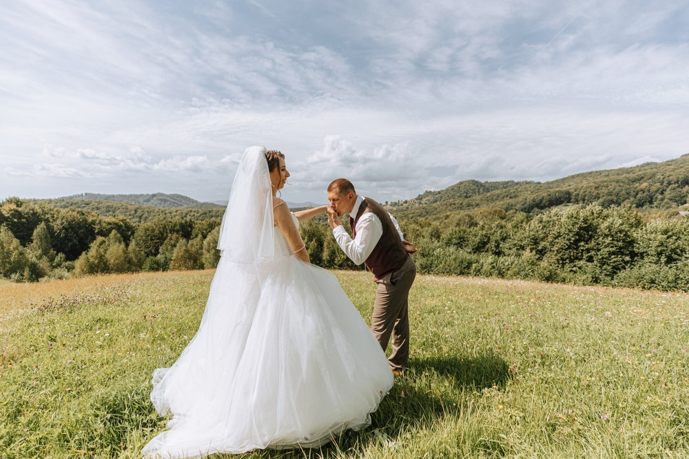 bride and groom on hilltop with mountain views