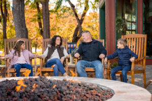 family sitting around outdoor fire pit at The Inn on the River hotel in Pigeon Forge in fall